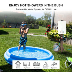 A child joyfully splashes in a small pool filled with warm water from a Camplux portable water heater.