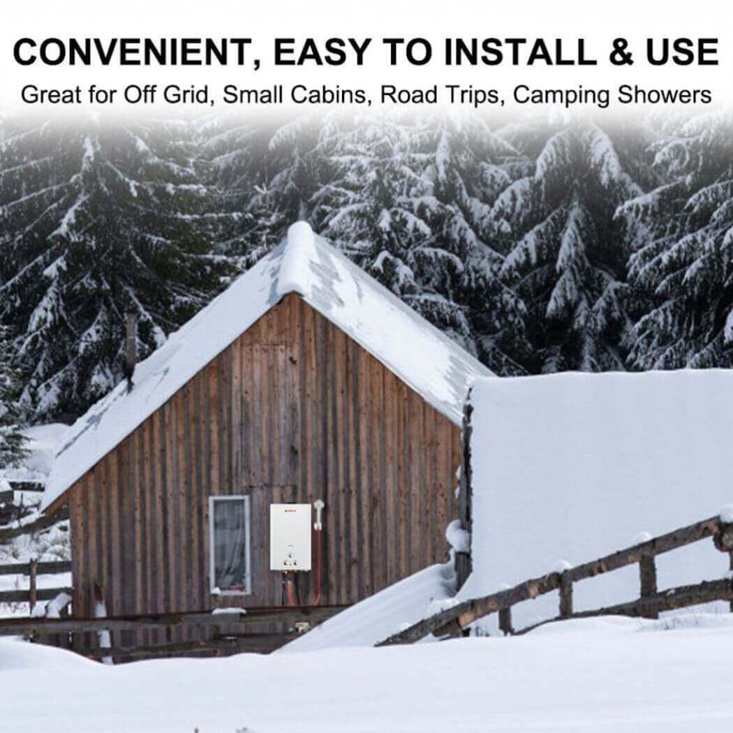 A snow-covered cabin with a camplux bw422 water heater hanging on the side.